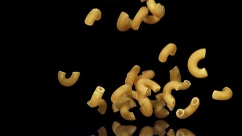 Dry Pasta Falls on the Black Table Filmed on a Highspeed Camera at 1000 Fps