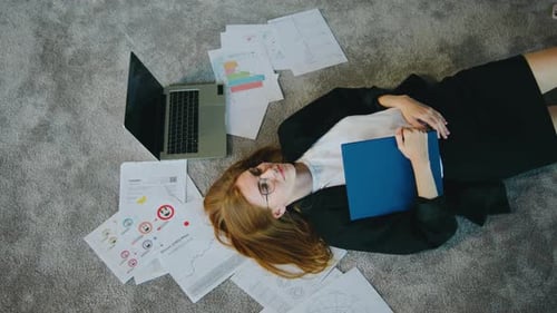 A Tired Businesswoman Looks Exhausted Amidst Work Documents Depicting Burnout Stress and Overwork in