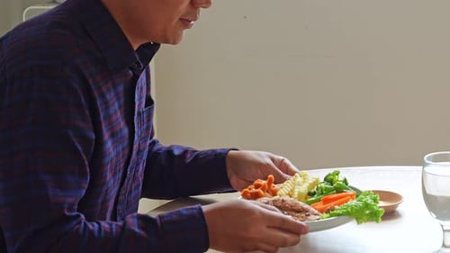 Adult enjoys a steak with vegetables