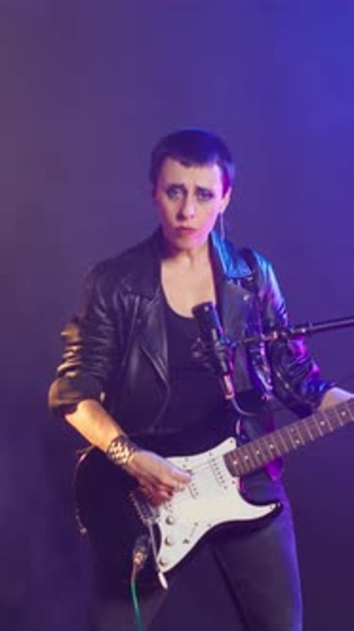 Vertical Video Punk Rock Girl with a Grunge Edgy Style Performing with a Bass Guitar