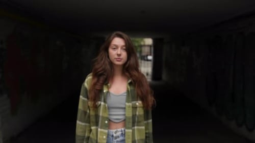 Young Woman Walking in Urban Graffiti Tunnel