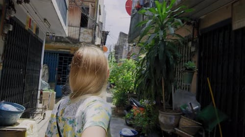 Jovem casal de mãos dadas, turista loira, liderando o namorado andando pela rua asiática de Bangkok...
