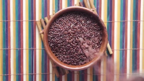 Uncooked Red Rice Grains in Bowl Overhead