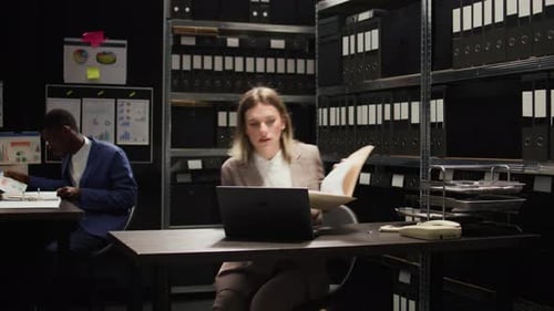 Woman Working at Computer in Dark, Small Office