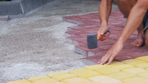 Worker Laying Stone Paving Slab