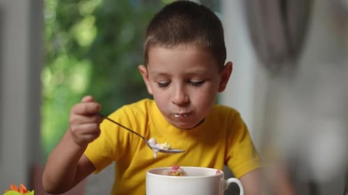 A Young Boy Happily Enjoying His Breakfast with Cheerful and Joyful Expressions on His Face