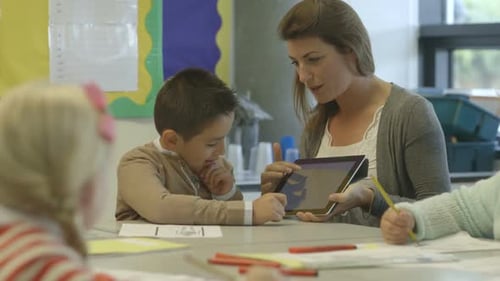 MS Teacher and school child using digital tablet in classroom