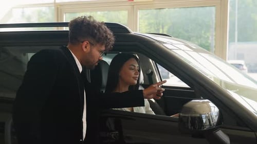 Car Salesman Showing New Car to Potential Customer