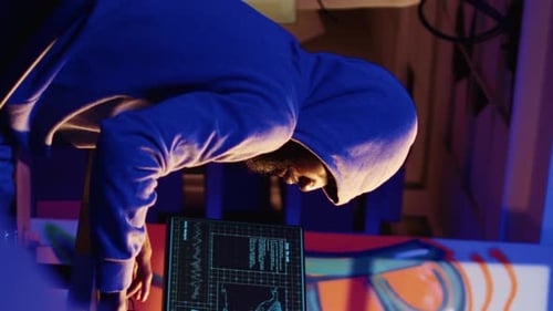 Hooded Hacker Working on Computer at Night