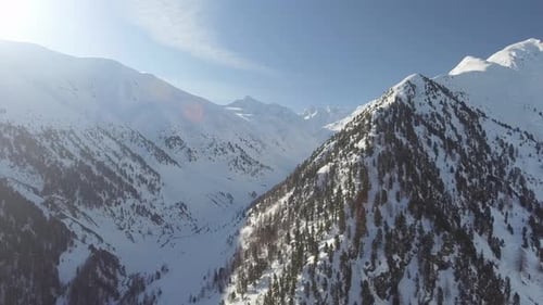 Aerial shot of a mountain ridge and inaccessible valley under the snow in Livigno, Italy.
