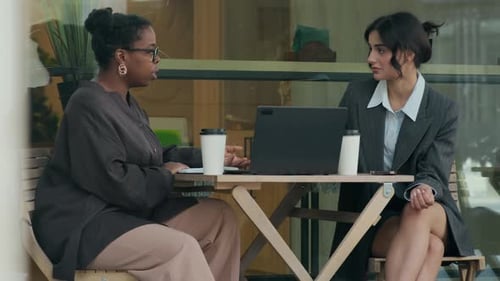 Two Businesswomen Chatting About Work, Sitting in Cafe During Coffee Break