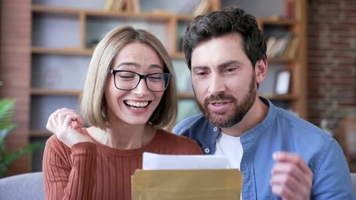 Excited Couple Read Letter with Happy News Together