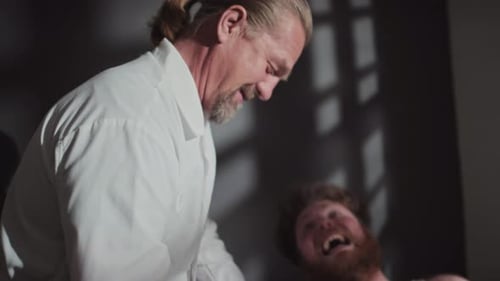 Doctor Restraining Patient in Hospital Bed