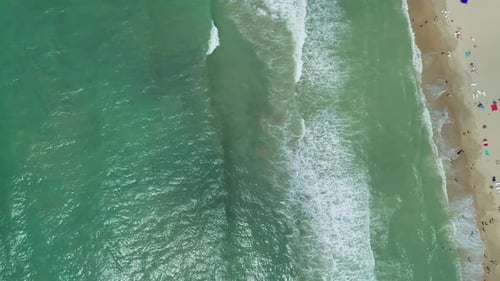 Aerial Over the Sandy Beach with Many People and Azure Water on a Sunny Summer Day Waves Crashing to