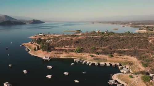 Aerial drone flying over a lake, water dam, with mountains at sunrise. Beautifull dreamy landscape.
