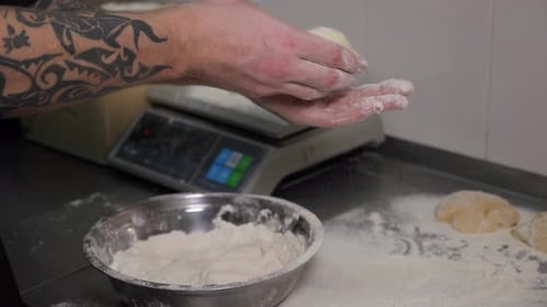 Closeup of a Chef Forming Round Burger Buns From Dough in an Industrial Kitchen