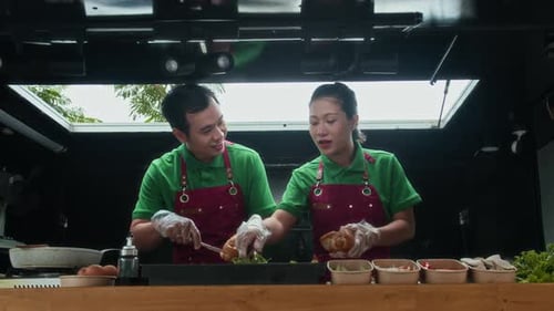 Trabajadores de un café callejero cocinando sándwiches en un camión