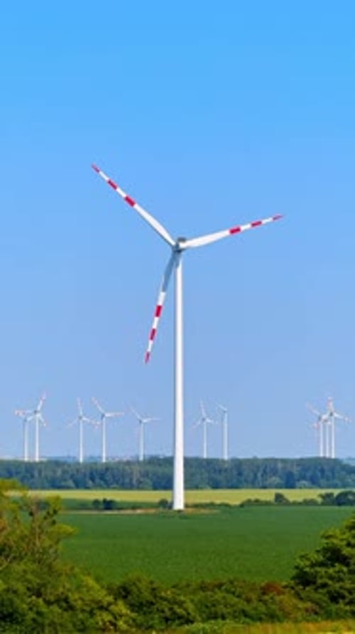 Windturbinen auf einem Feld. Eine große Windturbine steht prominent