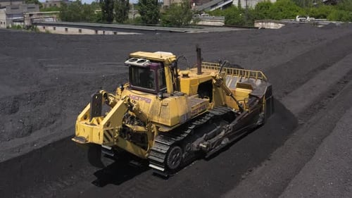 Luftaufnahme von Bulldozern, die Kohle auf ein Wärmekraftwerk lenken
