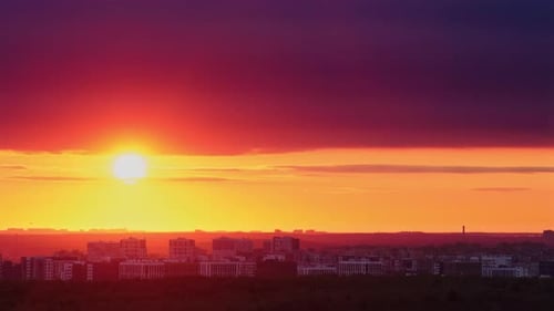 The evening sky is painted with vibrant red clouds during sunset, time lapse.