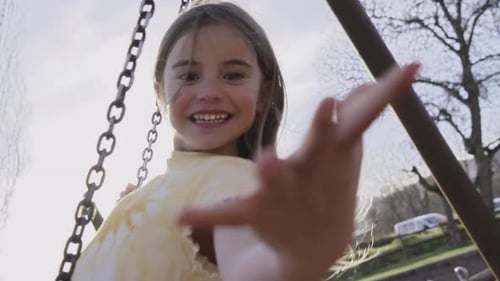 Little Blonde Girl Swinging Happily on a Wooden Swing in the Park People Enjoying Childhood