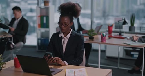Business woman using smartphone in modern office setting