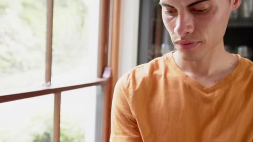 Young Adult Standing by Window Indoors