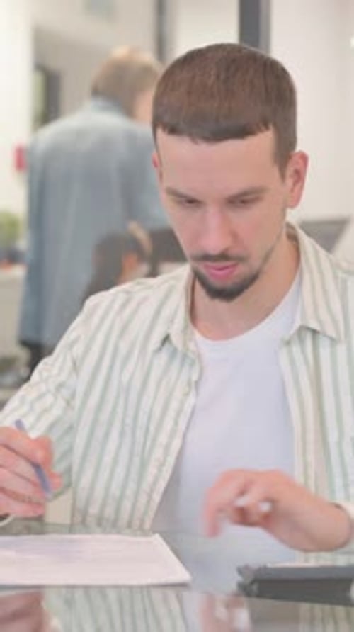 Creative Young Man Doing Financial Calculations of Business Report, vertical video