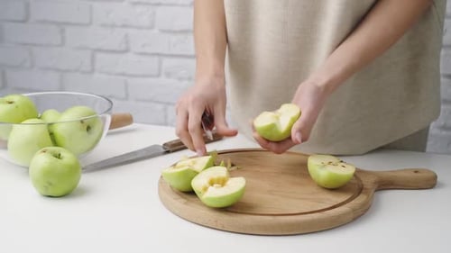 Woman Prepares Fresh Green Apples for Cooking