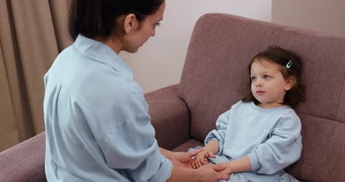Caring Woman Talking with Her Little Child Girl Supporting at Home