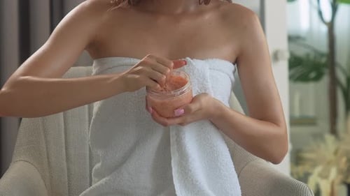 Woman Applies Exfoliating Scrub in Brightly Lit Interior