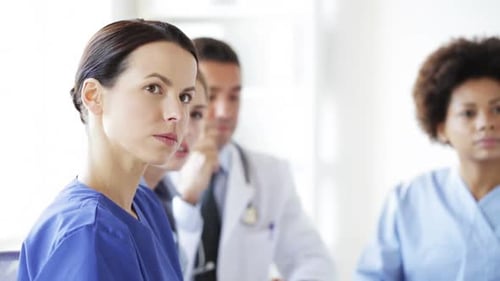 Doctors and nurses gather at a medical conference in a busy hospital
