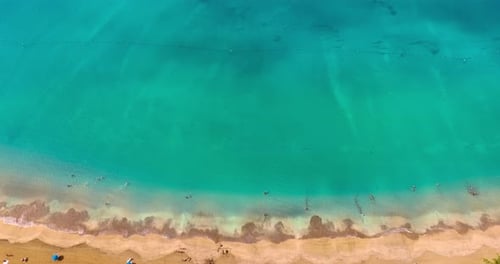 Flying over the sandy beach approaching the stunning turquoise waterscape.