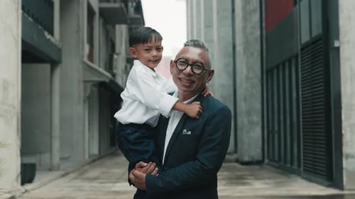 Smiling Man Holds Child in Alleyway