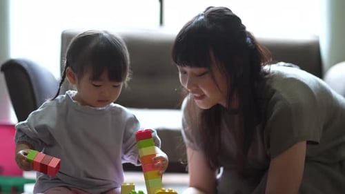 Mother and Child Playfully Building with Toy Blocks