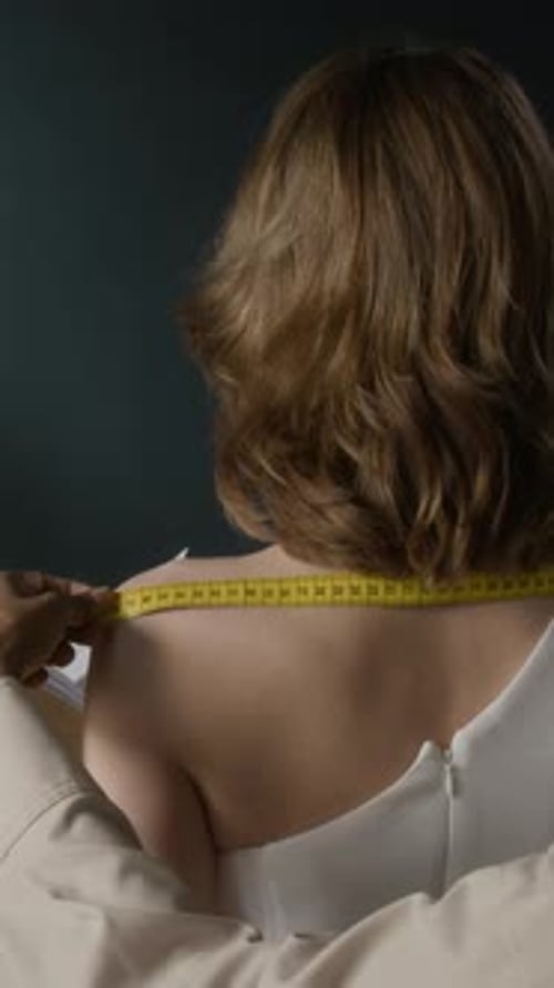 Tailor Measures Woman for Dress in Studio