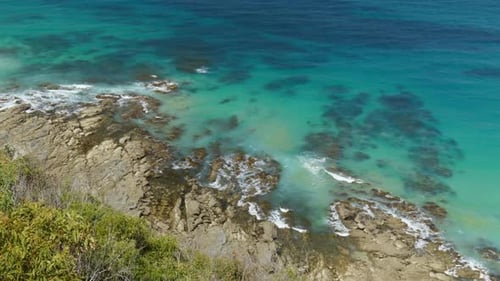 Wide Shot of Waves Crashing Over Reef Below