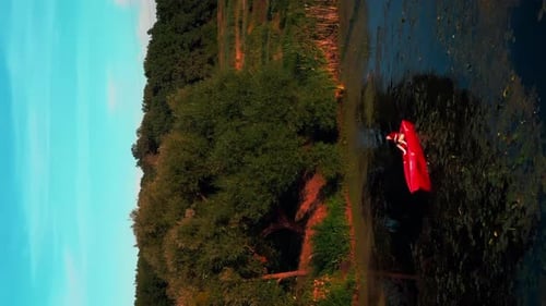 Woman Kayaking on Narrow River from Aerial Perspective