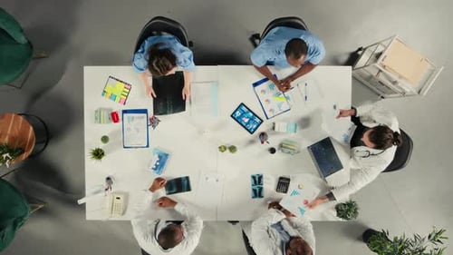 Top Down View Zoom in of Doctors Participating in a Healthcare Team Meeting