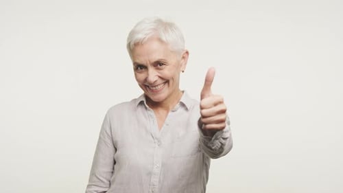 Positive Senior Woman Giving Thumbs Up on White Background