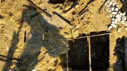 Aerial view of an excavator positioned on a construction site, preparing to clear the remaining debr