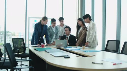 Diverse Business Team Collaborating on Laptop in Office