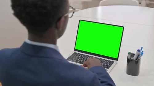 Vista aérea del joven empresario usando una computadora portátil con pantalla verde