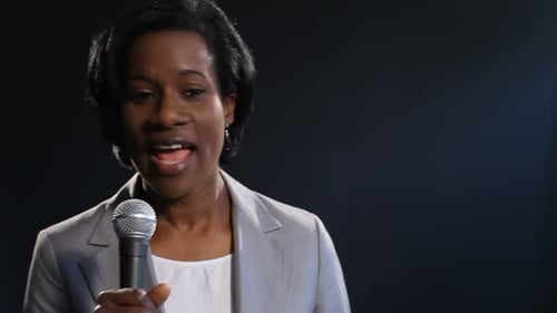 Confident Woman Speaking Into Microphone