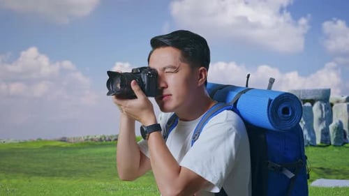 Vue latérale rapprochée d'un homme asiatique utilisant un appareil photo prenant une photo à Stonehenge