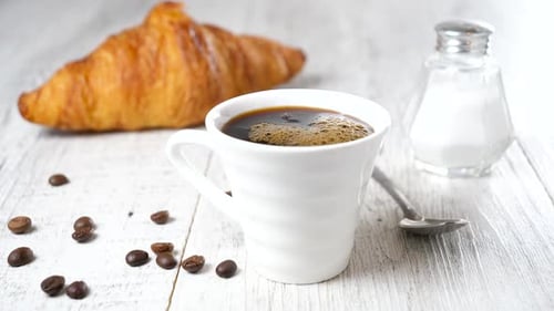 Coffee Being Poured with Croissant and Sugar