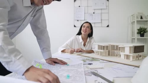 Architects Collaborate on Building Model in Office Setting