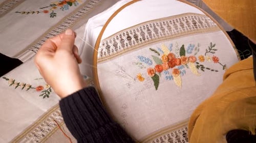 Hands Embroidering Flowers on White Linen Fabric