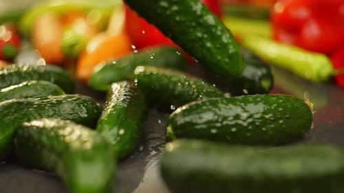 Slow Motion Video of Cucumbers Falling with Vegetables Background