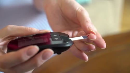 Diabetic Patient Measuring Blood Glucose Level with a Glucometer